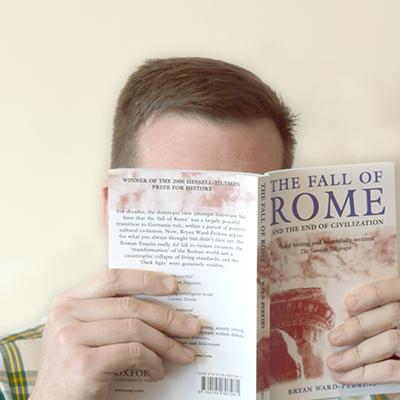 Headshot of Sam Gedman holding a book