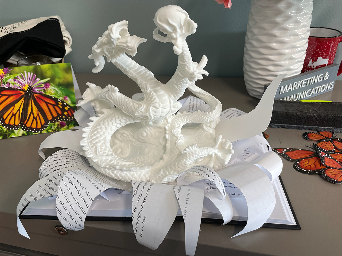3D printed dragon emerging out of a book