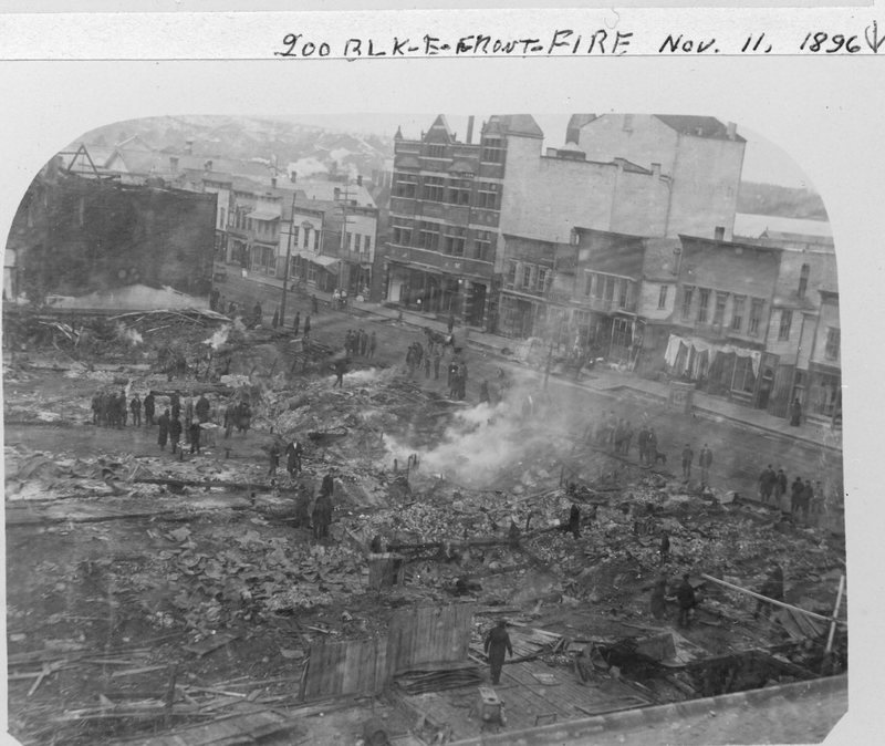 Black and white photograph of the ruins of south side of Front Street, across the street standing buildings including Steinberg's Opera House