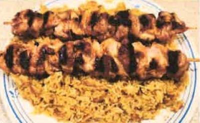plate with two amerasian chicken skewers and orange rice