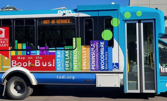 Regional bus with colorful book graphic along the sides